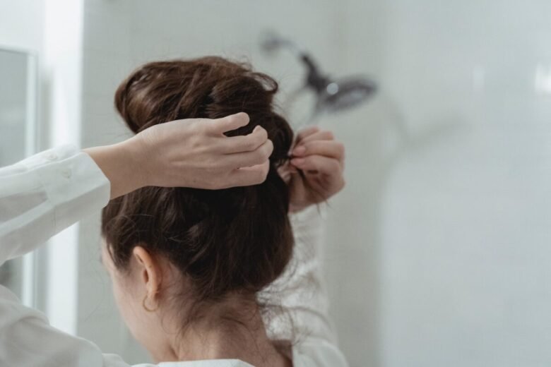 Una ragazza si fa uno chignon allo specchio