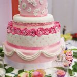 Torta sui toni del rosa decorata con roselline in pasta di zucchero