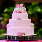 Torta rosa a quattro piani con fiorellini