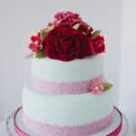 Torta rosa con composizione di fiori rossi