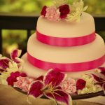 Torta rosa e fucsia con fiori e nastri