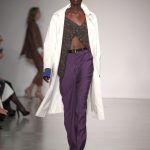 Completo pantaloni viola su top asimmetrico e soprabito bianco