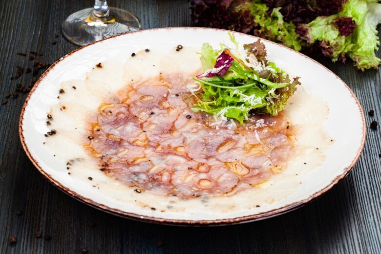 Carpaccio di pesce spada affumicato e rucola con limone e pepe rosa