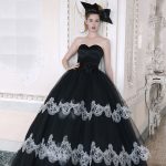 Abito principessa con pizzo bianco su fondo nero.