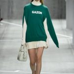 Lacoste felpa verde con dettagli bianchi abbinata a minigonna a pieghe