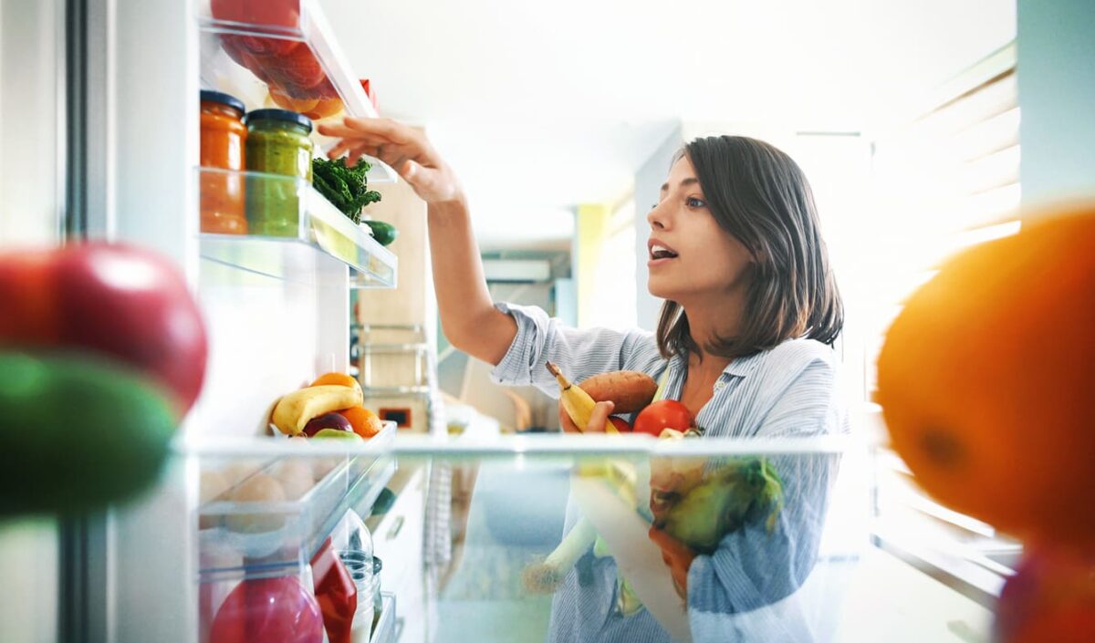 ragazza che prende verdura dal frugo