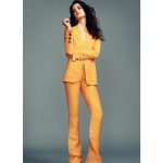 Eva Green indossa pantaloni a vita alta gialli con giacca in tono