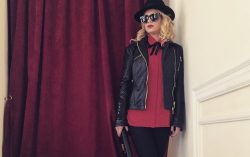 Chiodo in pelle, cappello nero e camicia rossa sono elementi costanti negli outfit di Emma