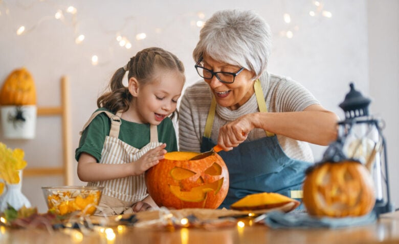 Nonna e nipote che scavano e intagliano la zucca di Halloween