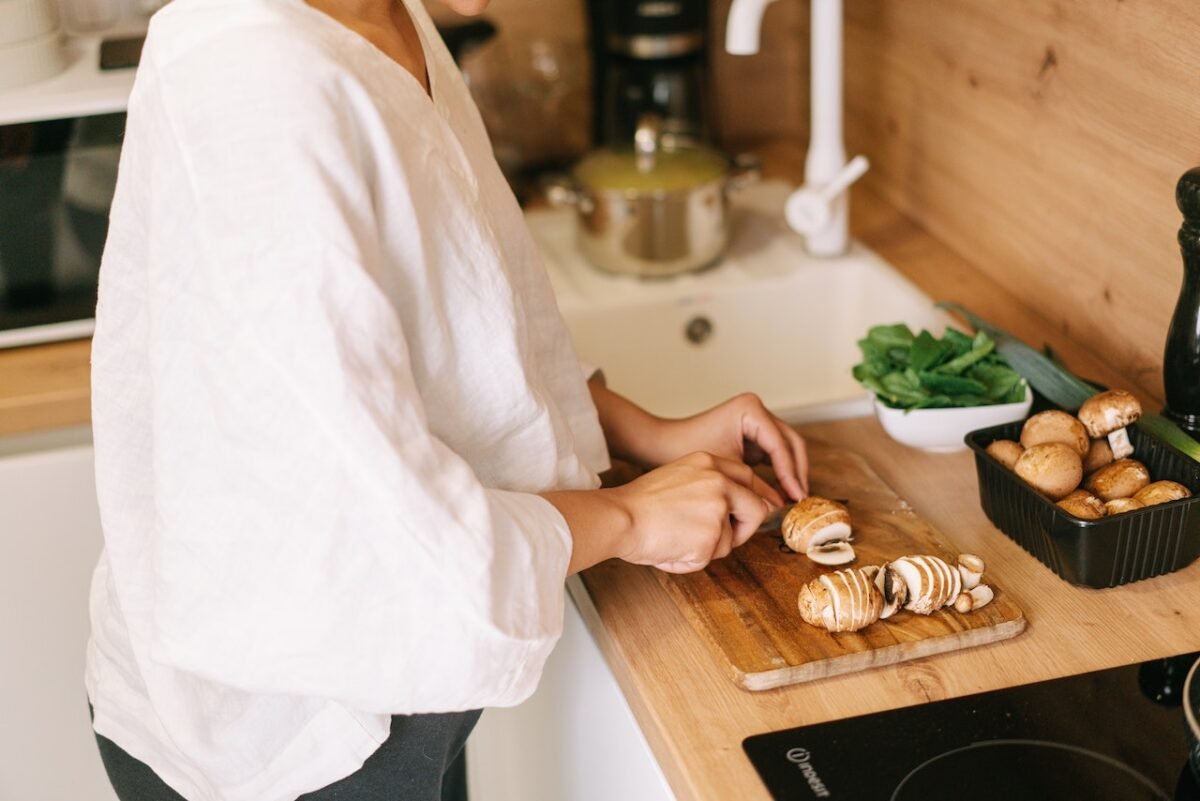 donna che taglia i funghi in cucina