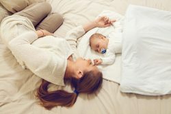 Mamma che guarda il suo bambino dormire