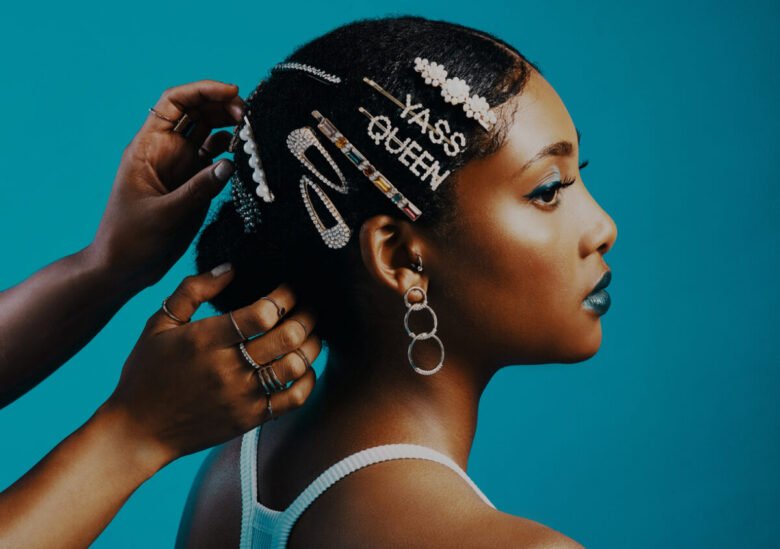 Ragazza di profilo si sta facendo acconciare i capelli con fermagli e ferretti