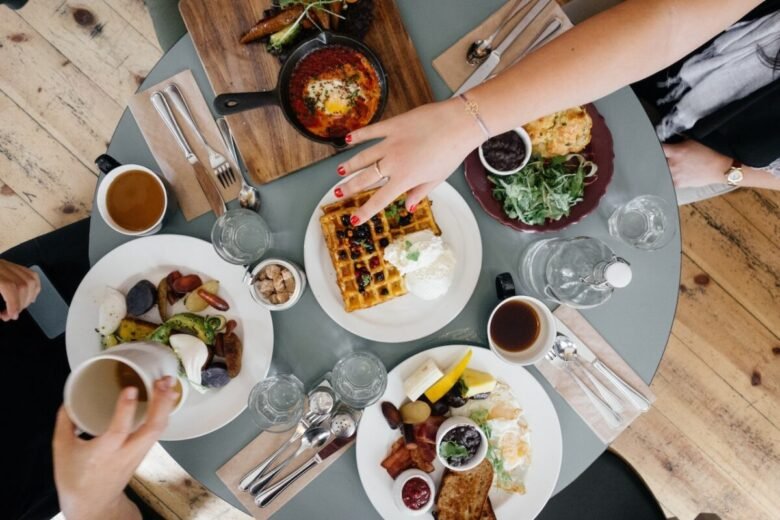 Tavola imbandita per una colazione all'americana con waffle e pancakes