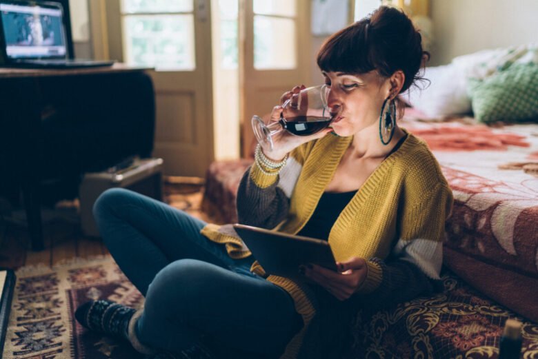 ragazza che beve vino a casa