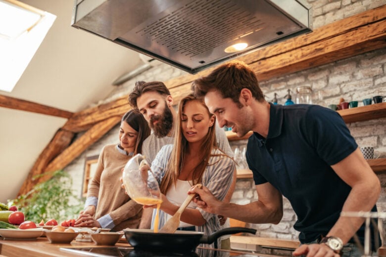 Un gruppo di amici che cucina divertendosi