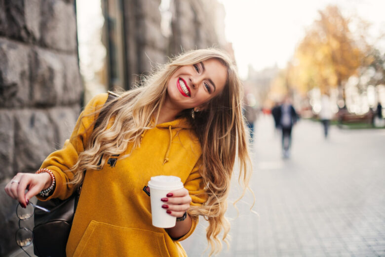 Una ragazza bionda con un vestito giallo sorride