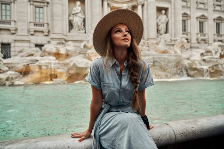Ragazza con abito seduta sulla fontana di Trevi