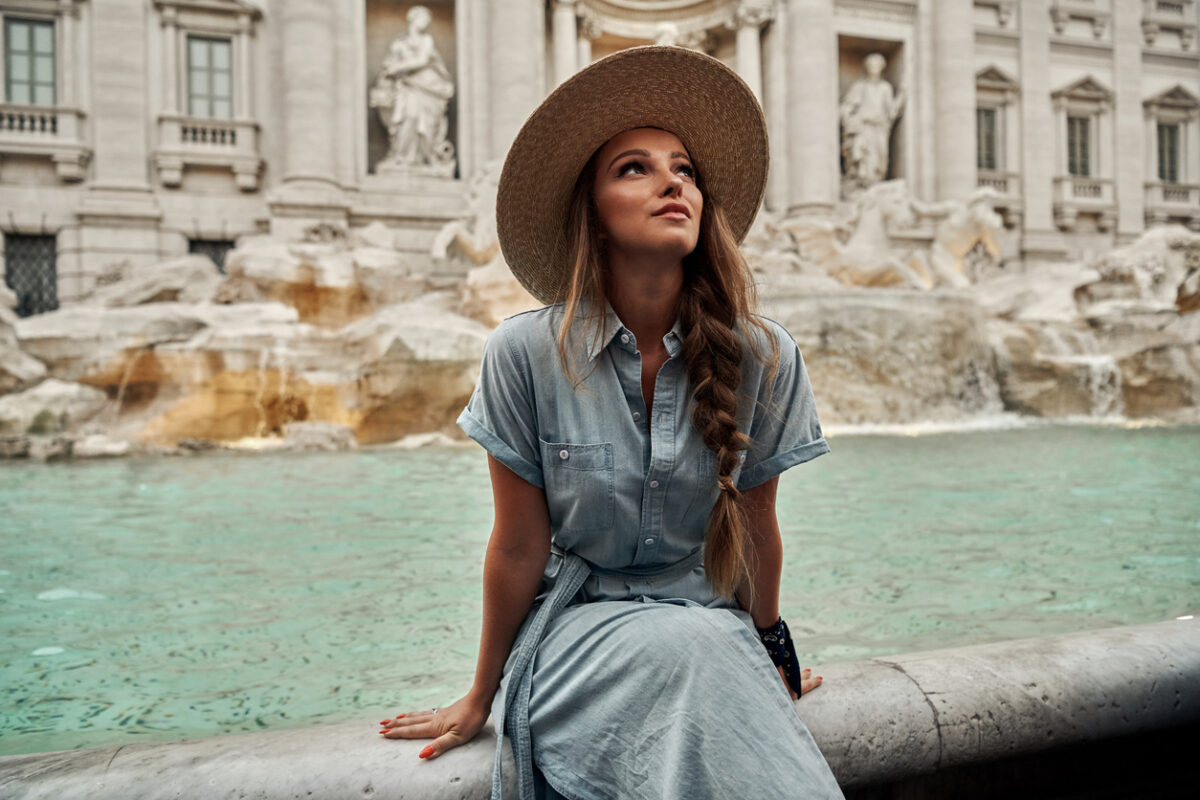 Ragazza con abito seduta sulla fontana di Trevi