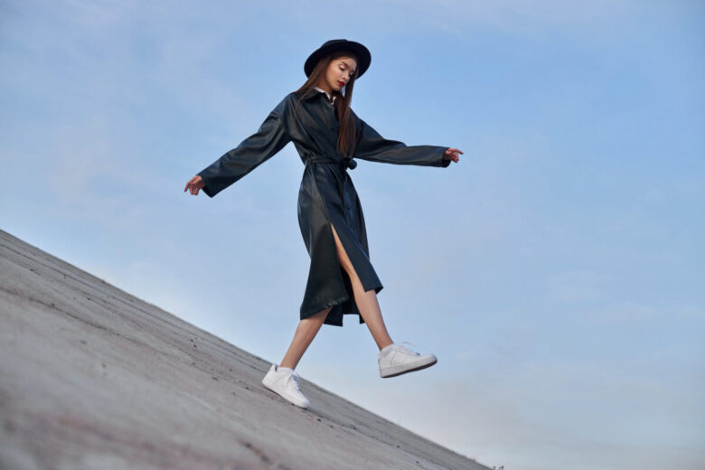 Una ragazza con un outfit nero e un cappello molto chic fotografata durante una fashion week