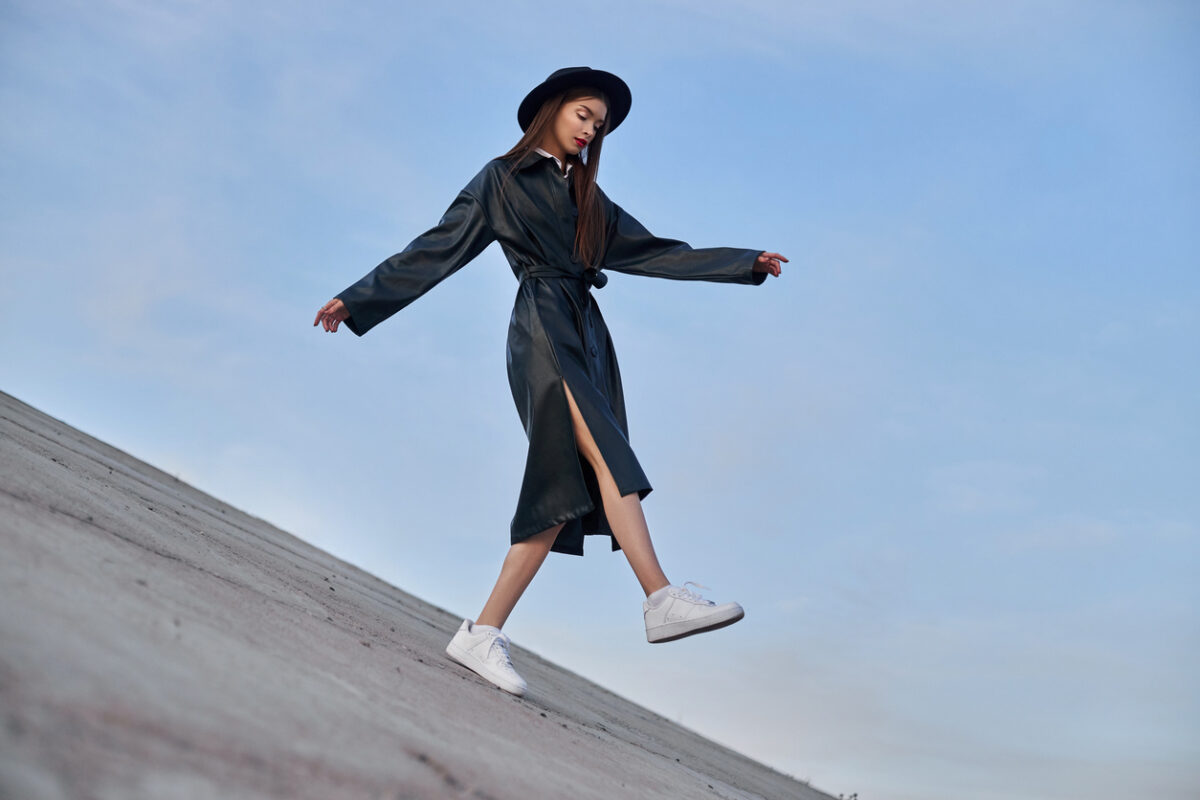 Una ragazza con un outfit nero e un cappello molto chic fotografata durante una fashion week