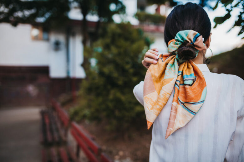 Una ragazza con uno chignon basso legato con un foulard