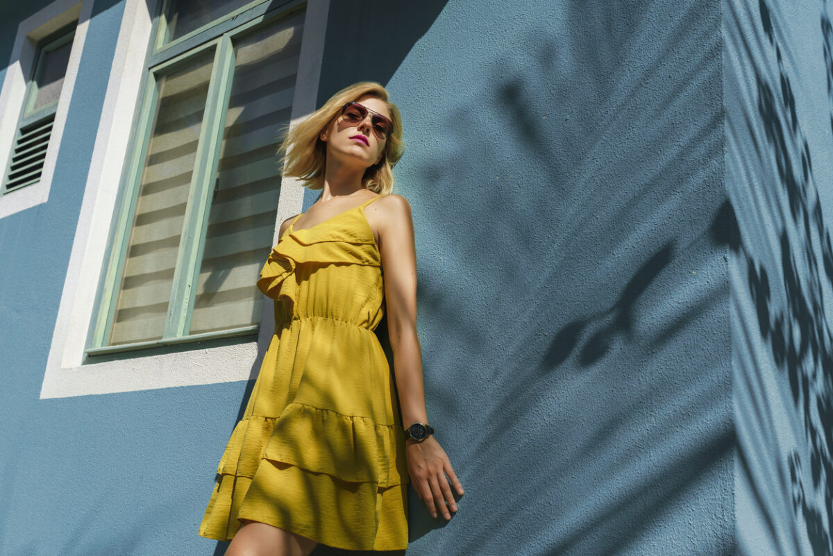Ragazza con vestito estivo appoggiata al muro
