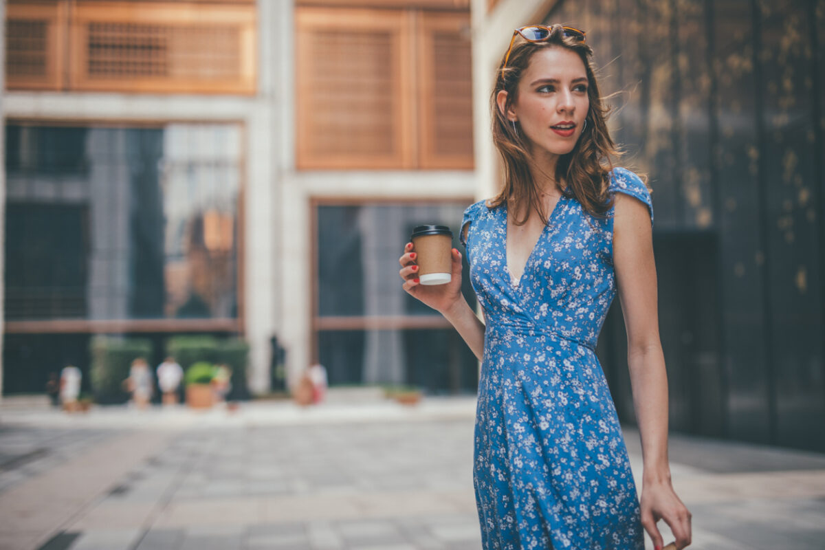 Donna che passeggia in città con un abito blu
