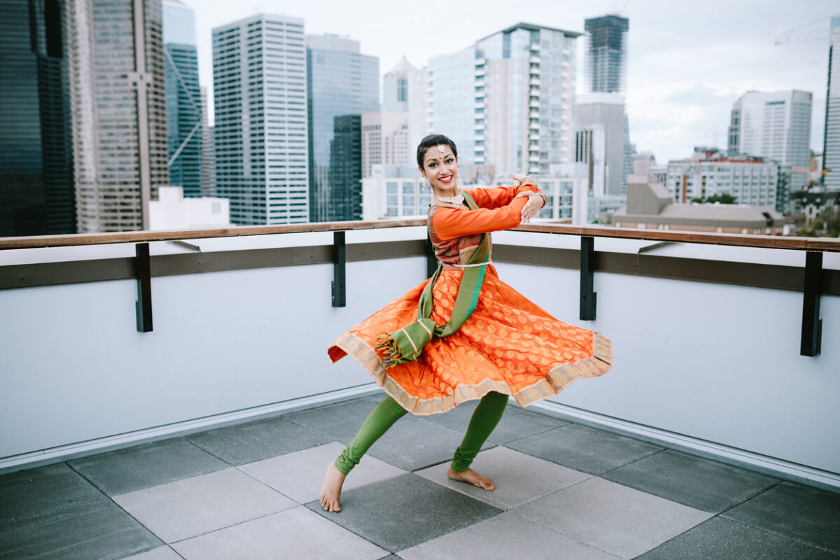 Ragazza balla una danza indiana con il costume e il makeup tipici su un balcone in America