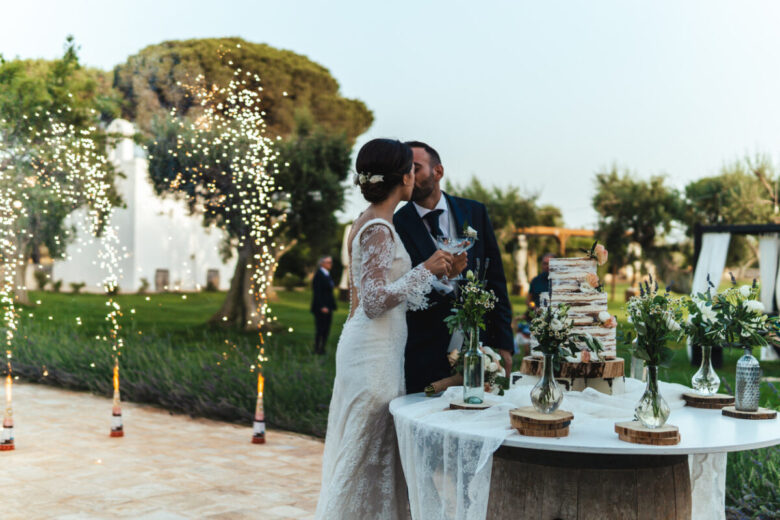 Coppia di sposi fotografata durante il momento del taglio della torta
