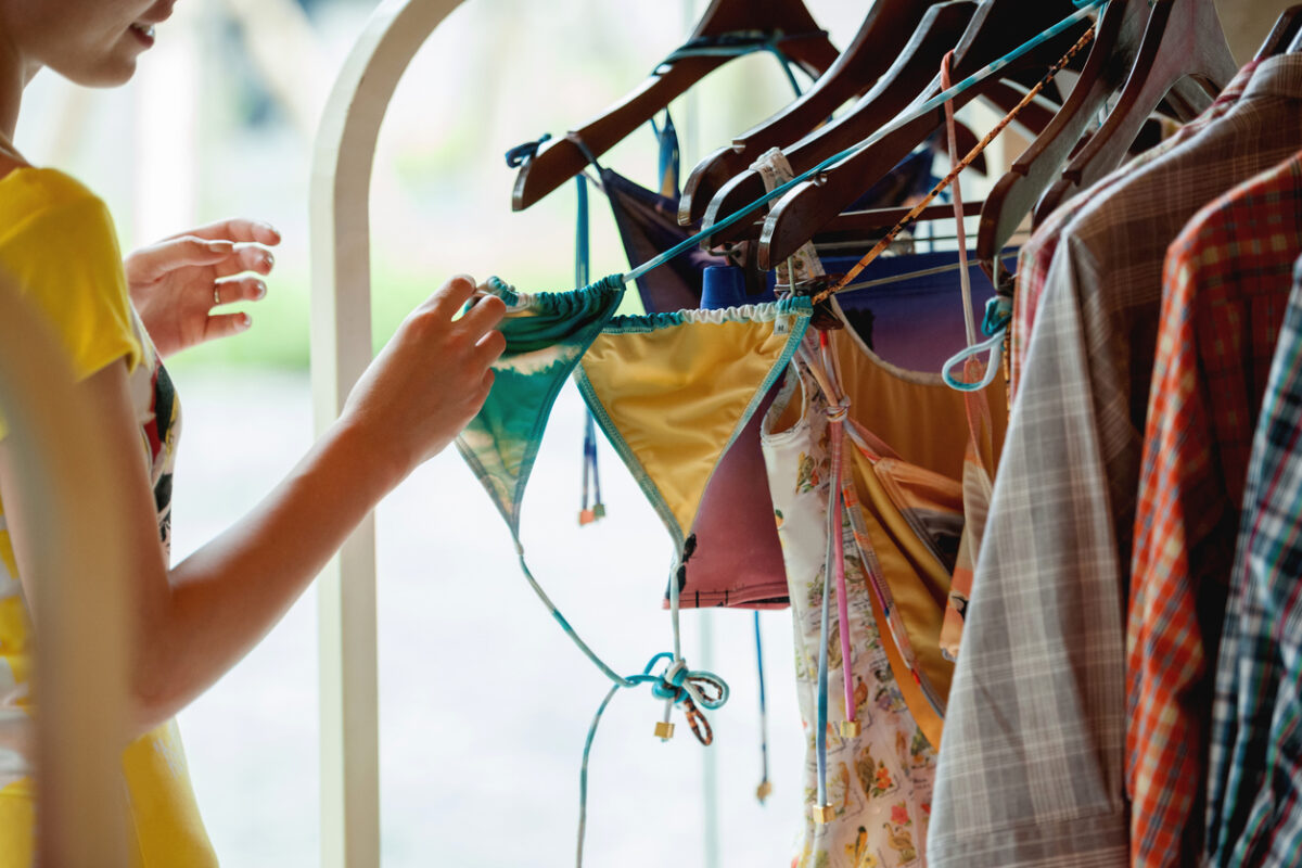 Ragazza che sta facendo shopping e scegliendo i costumi in una boutique