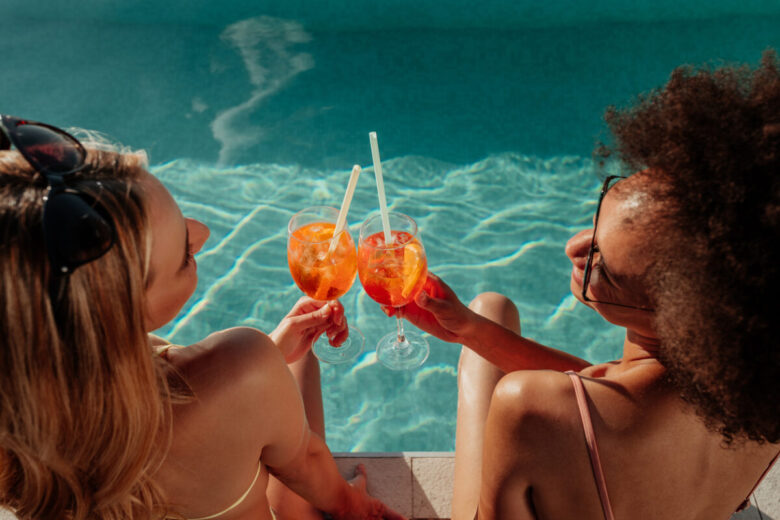 due ragazze in piscina con un cocktail