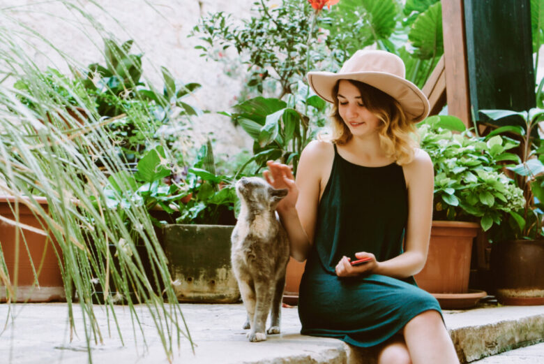 Ragazza che coccola un gatto in giardino
