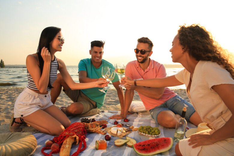 gruppo di amici al mare che mangia in spiaggia