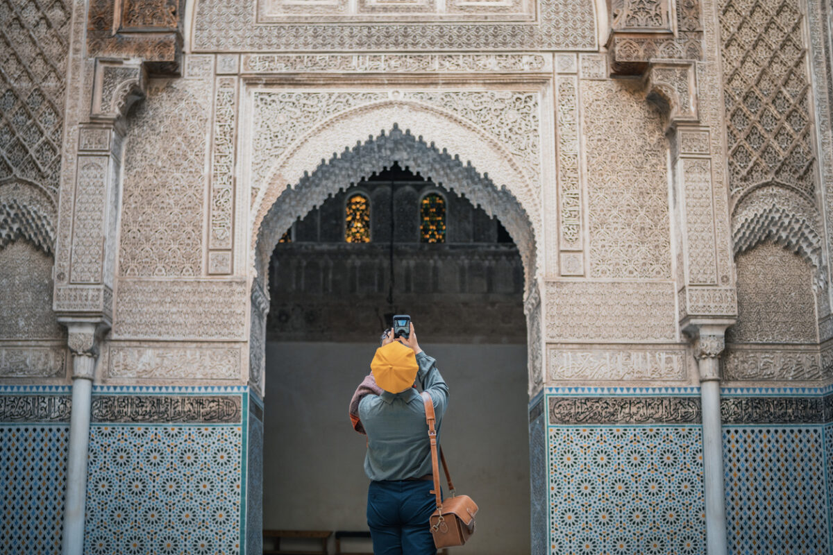 turista che fotografa e ammira la moschea di Fez Bou Inania Madressa