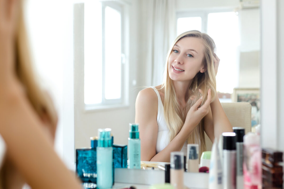 Ragazza che si sta pettinando i capelli davanti allo specchio