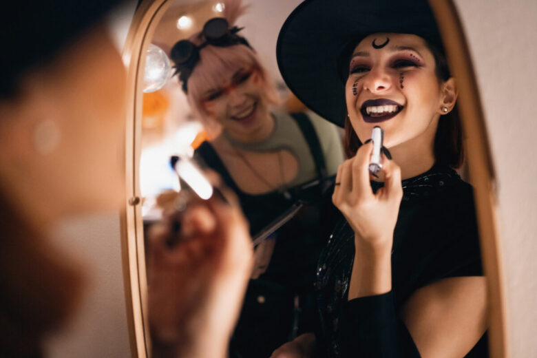 due ragazze si stanno truccando allo specchio da streghe per Halloween