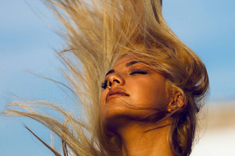 Una donna con i capelli al vento (ph. Unsplash)