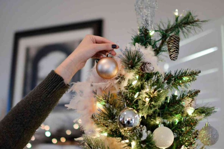 Una donna prepara l'albero di Natale (ph Unsplash)