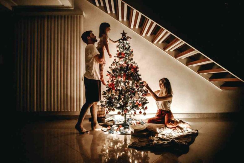 Una famiglia prepara l'albero di Natale (ph Unsplash)