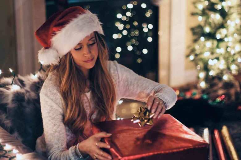 Una donna prepara un regalo di Natale (ph Unsplash)