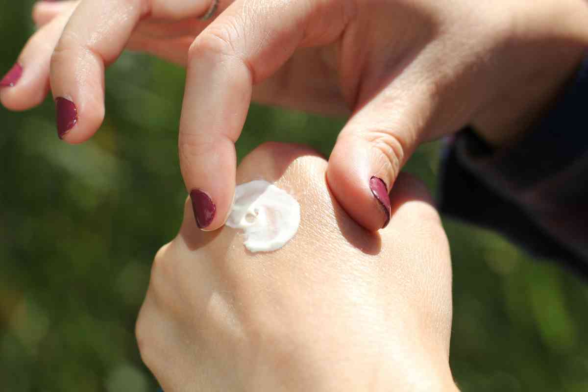 Una donna applica la crema sulle mani (ph Unsplash)
