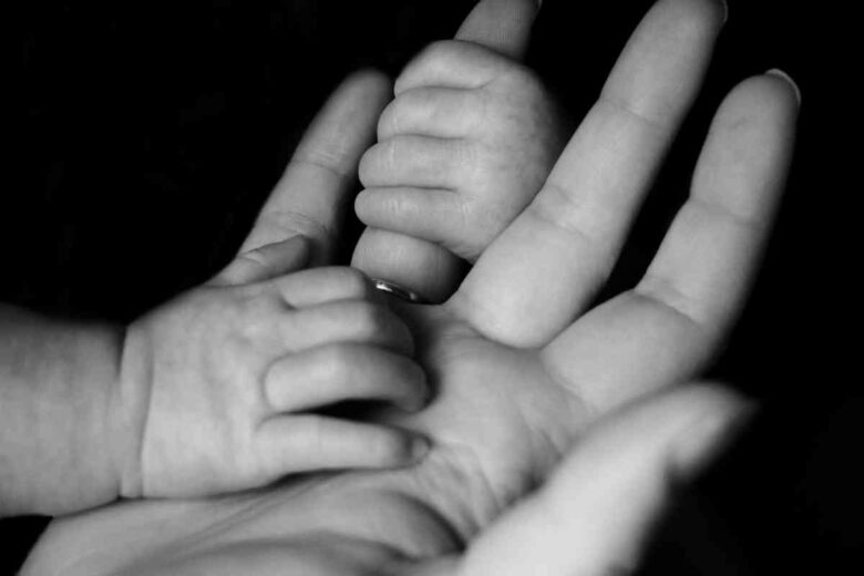 La mano di una madre e quella di suo figlio (ph Unsplash)