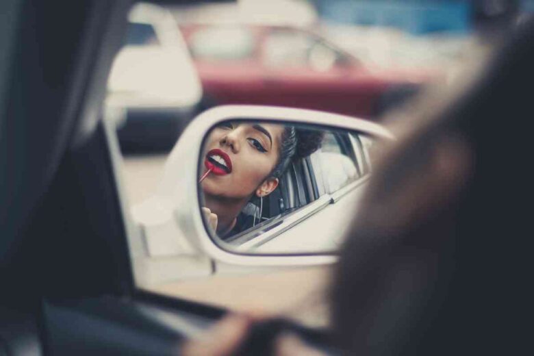 Una donna si trucca in auto (ph Unsplash)