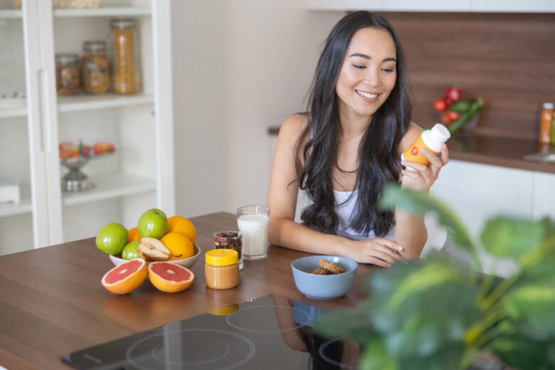ragazza che si sta per prendere gli Integratori alimentari a colazione