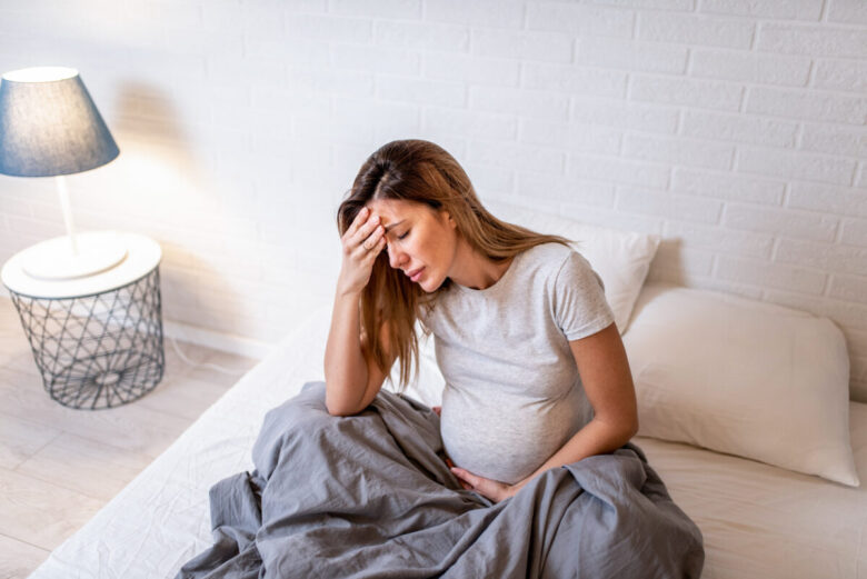 ragazza incinta dolorante sul letto