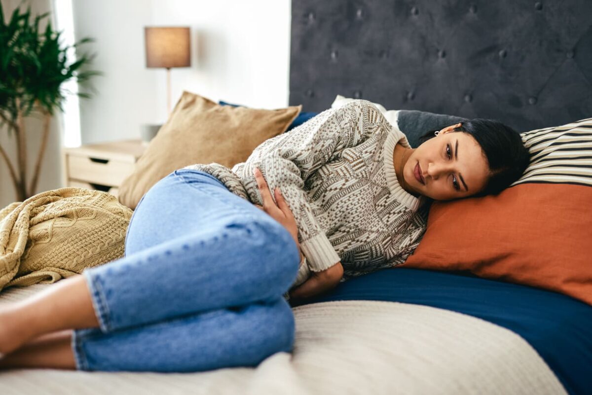 ragazza a letto mal di pancia