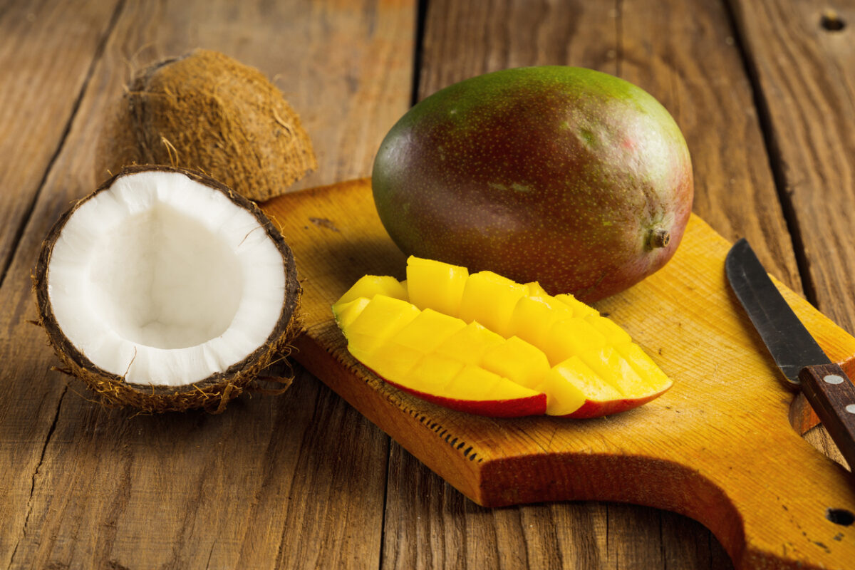 Fresh juicy cutting mango and coconut on a wooden table