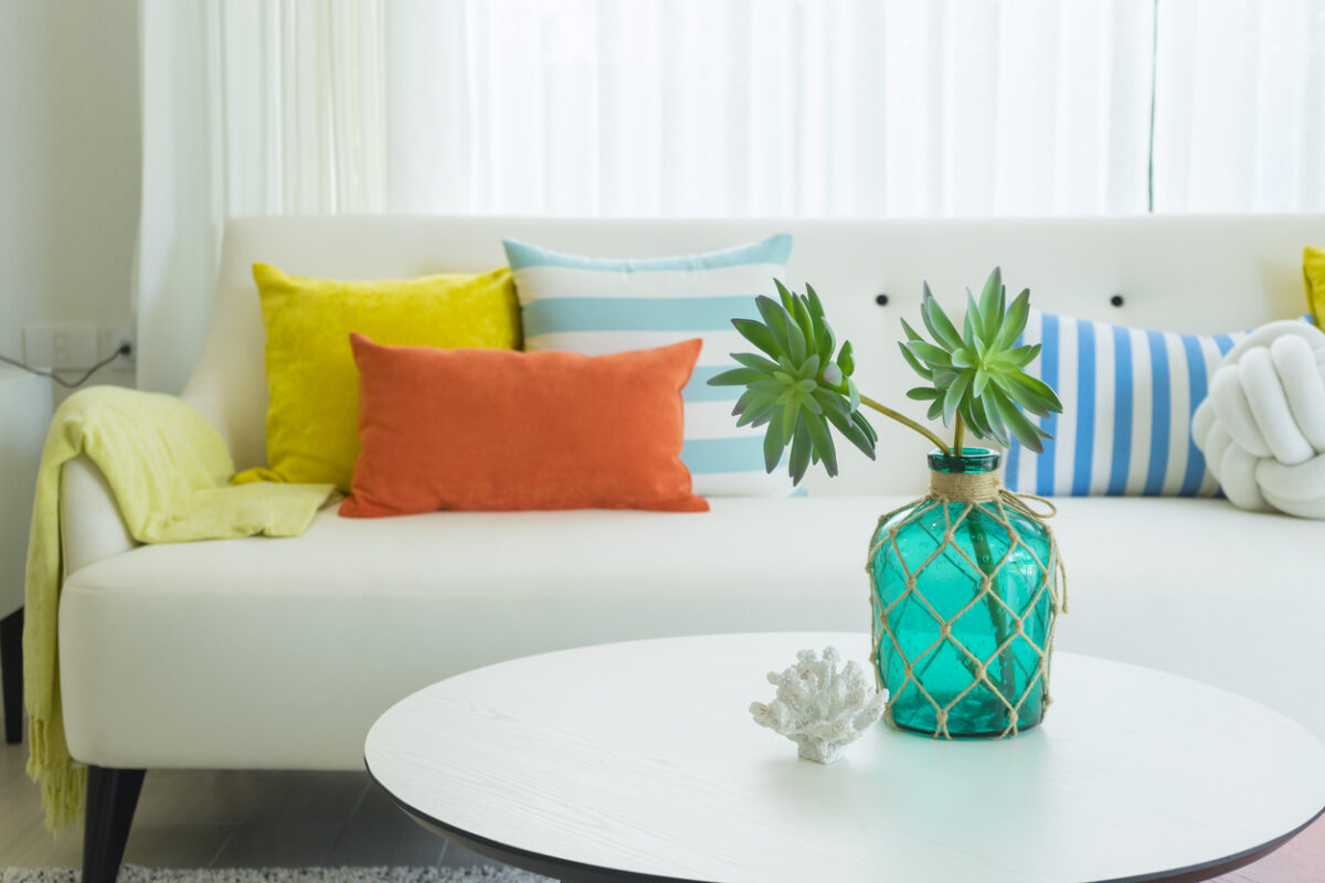 Modern design of living room with yellow,blue and orange pillow on sofa. Modern coastal home interior.
