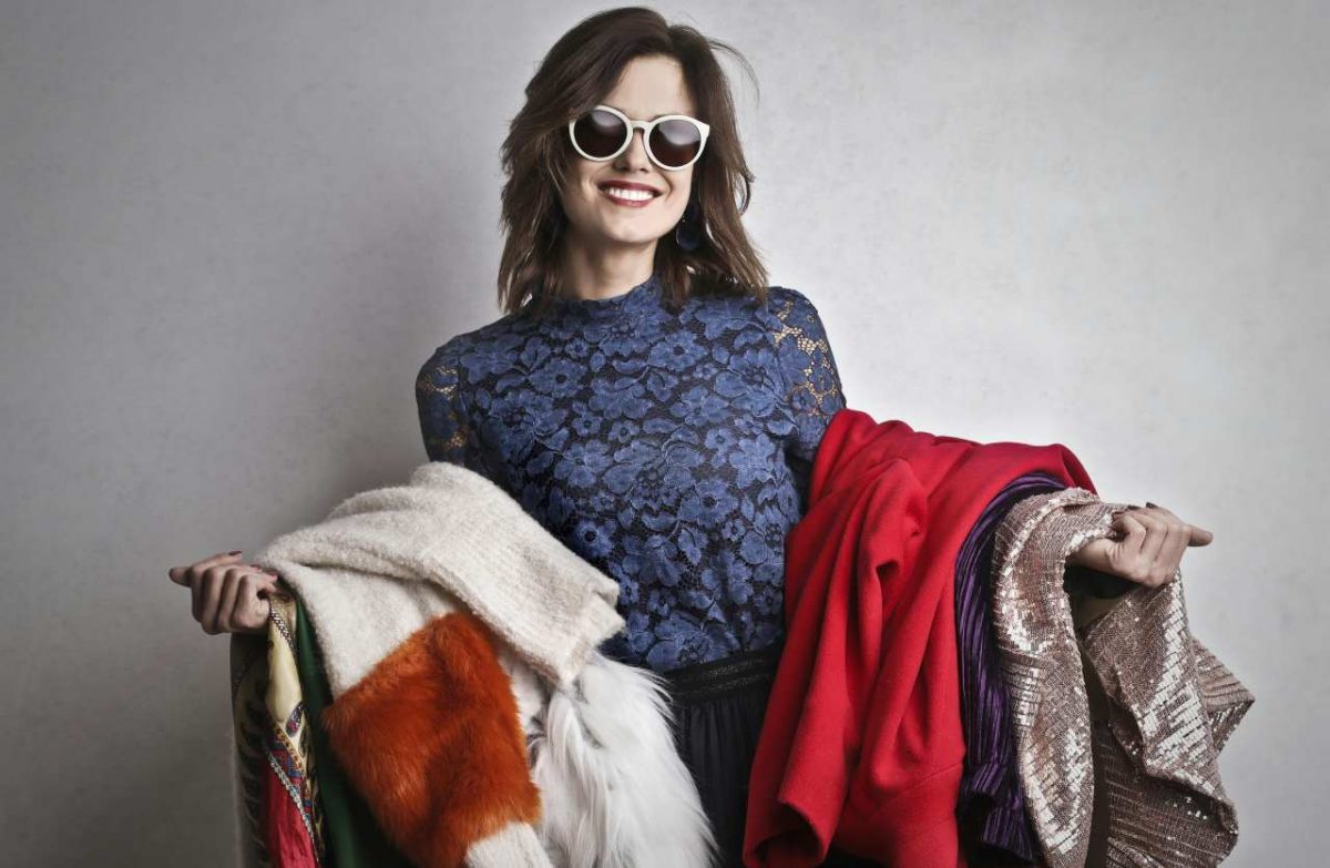 donna con abiti sulle braccia