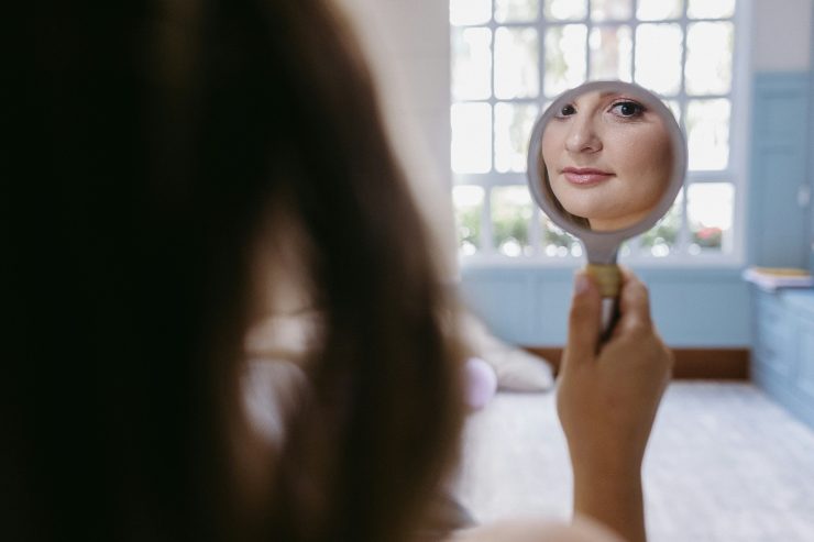 donna di spalle che si guarda allo specchio 